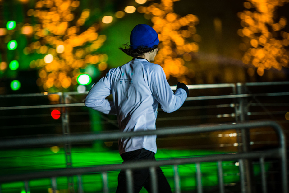 Ένας άντρας τρέχει με φόντο φωτισμένα δέντρα