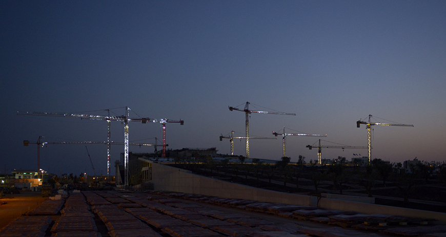 Μακρινή φωτογραφία που δείχνει γερανούς τοποθετημένους μέσα σε ένα εργοτάξιο