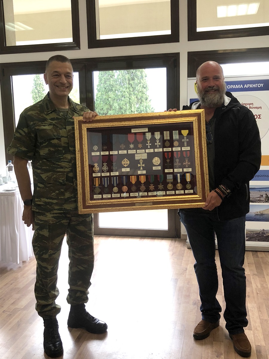 Ο Ανδρέας Δρακόπουλος και το μέλος της Ακαδημίας του Ελληνικού Στρατού κρατούν μια κορνίζα γεμάτη με στρατιωτικά μετάλλια