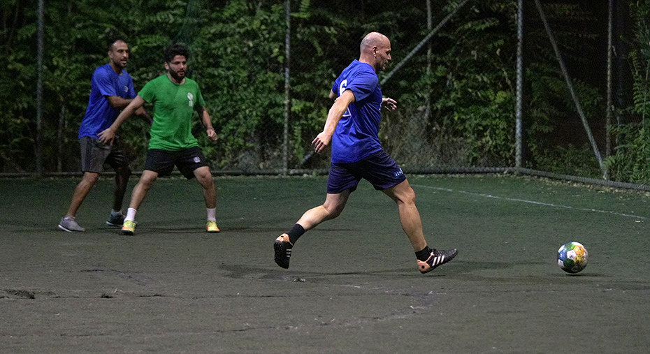 Ένας άνδρας σηκώνει το πόδι του για να κλωτσήσει μια μπάλα ποδοσφαίρου