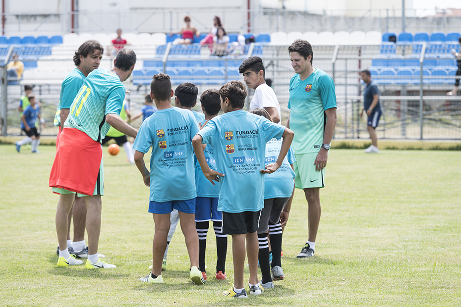 Μια ομάδα αγοριών συζητά με τους προπονητές σε ένα γήπεδο ποδοσφαίρου