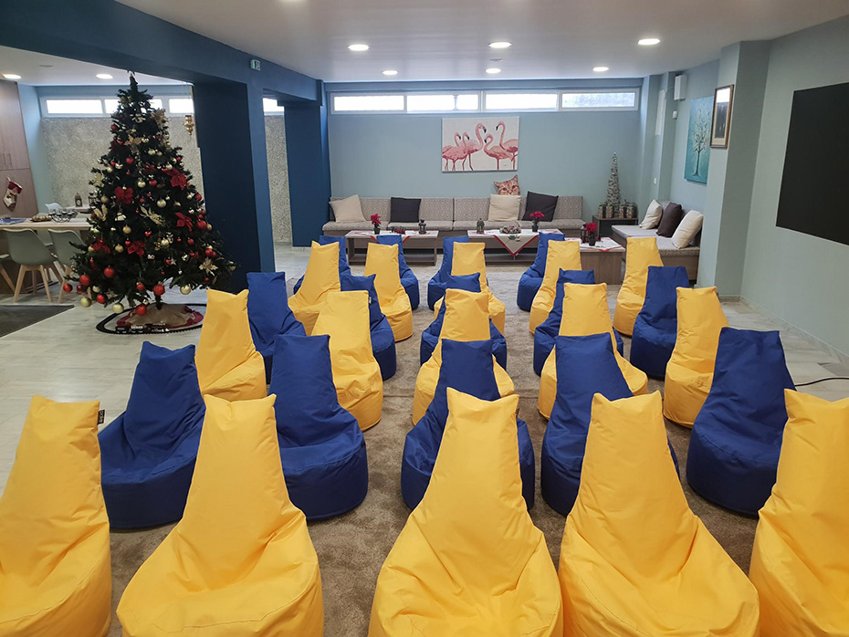 Μια φωτογραφία από το εσωτερικό της Νέας Αίθουσας, η οποία διαθέτει πολλές πολυθρόνες pouf 