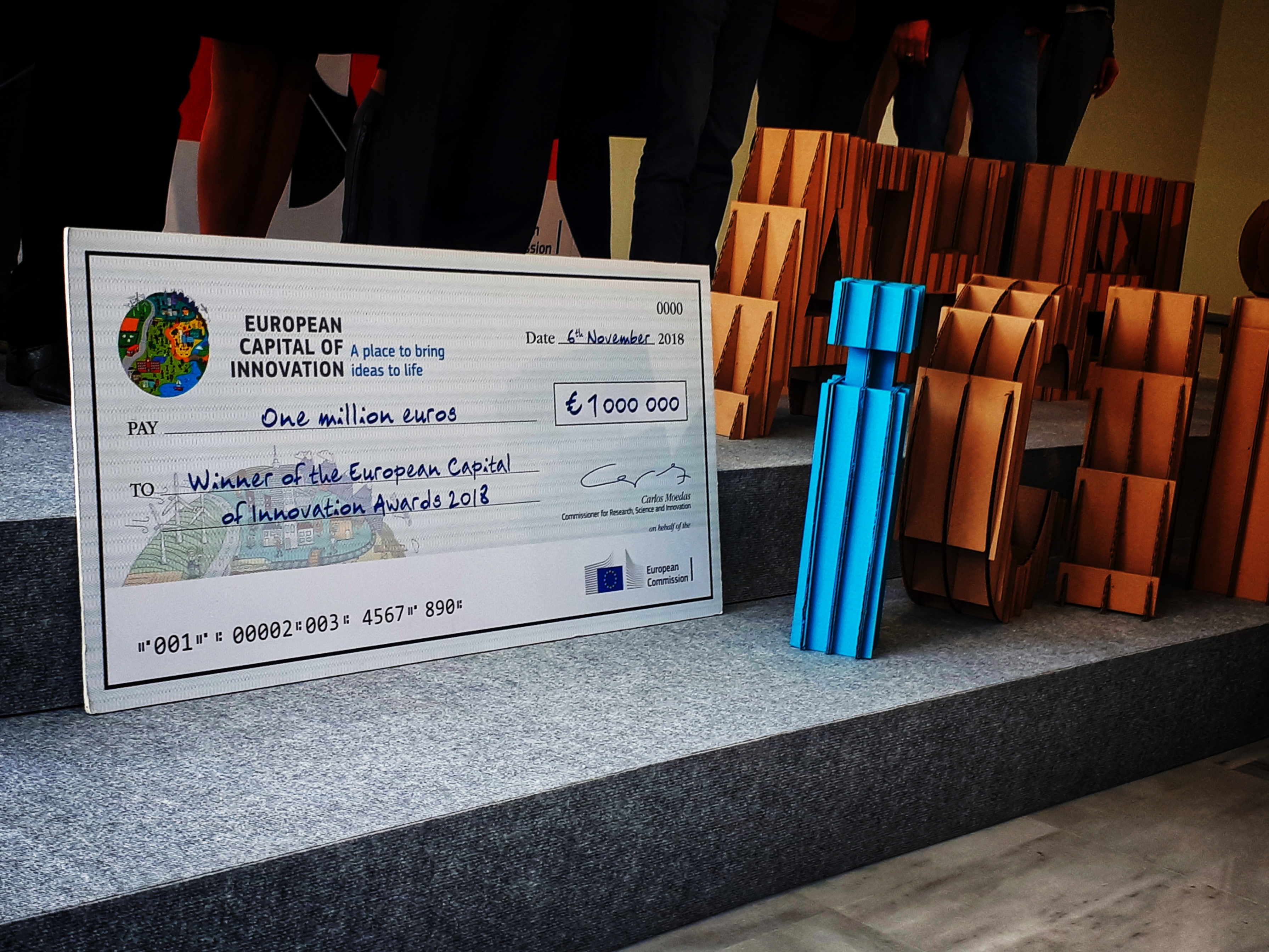 Μια φωτογραφία που δείχνει μια επιταγή σε μεγάλη μακέτα η οποία είναι το δώρο της νικήτριας ομάδας για την Ευρωπαϊκή Πρωτεύουσα Καινοτομίας