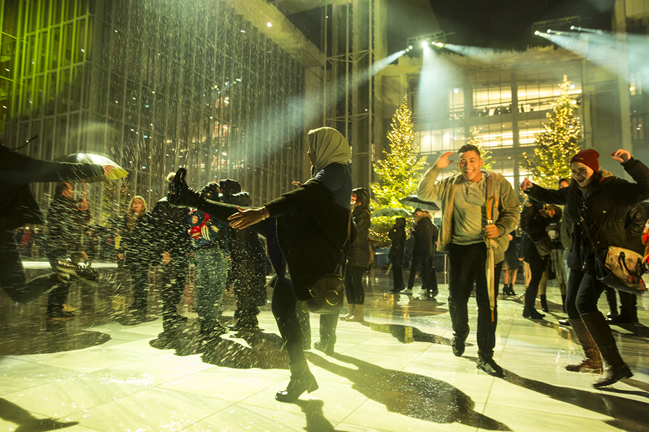 Άνθρωποι πλατσουρίζουν μεταξύ τους μπροστά από το Κέντρο Πολιτισμού Ίδρυμα Σταύρος Νιάρχος