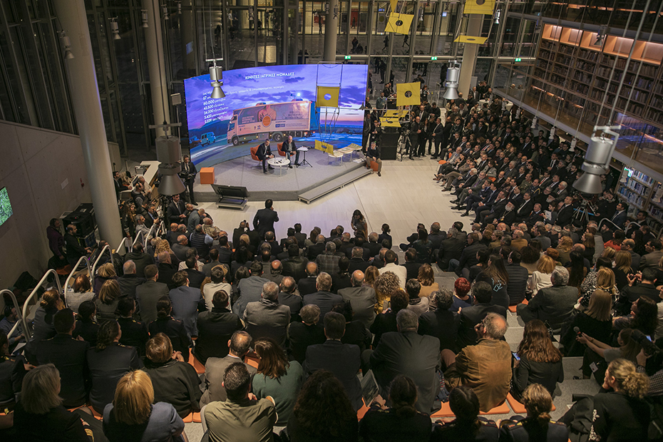 Φωτογραφία τραβηγμένη από ψηλά που δείχνει το κοινό να παρακολουθεί τους δυο ομιλητές που κάθονται στη σκηνή