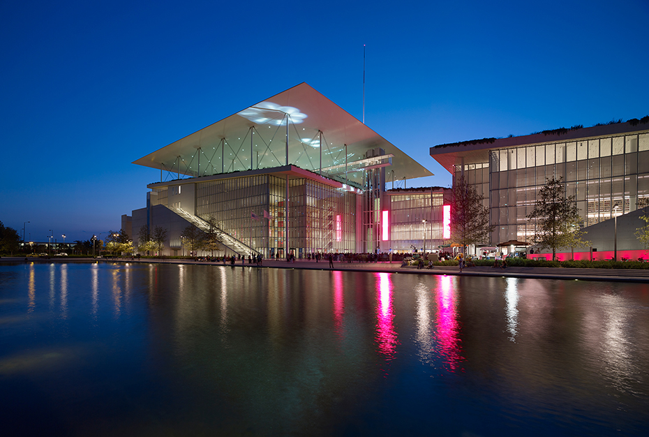 Φωτογραφία που δείχνει μια λίμνη πίσω από την οποία υπάρχει ένα μεγάλο γυάλινο κτήριο 