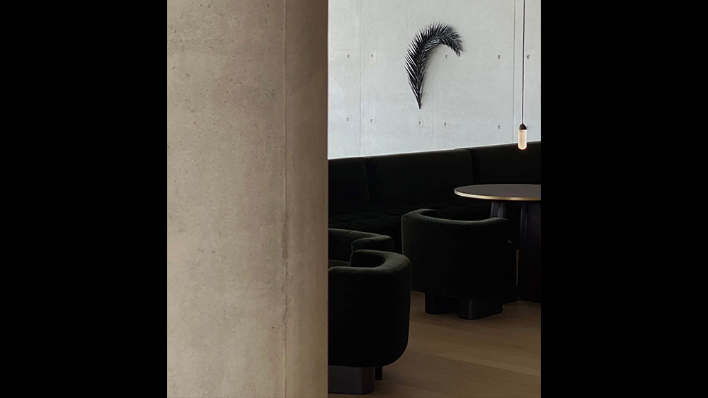 Ένα έργο τέχνης που μοιάζει με ένα μακρύ, καμπυλωτό φύλλο εκτίθεται πάνω από δύο τραπέζια στο εστιατόριο Delta