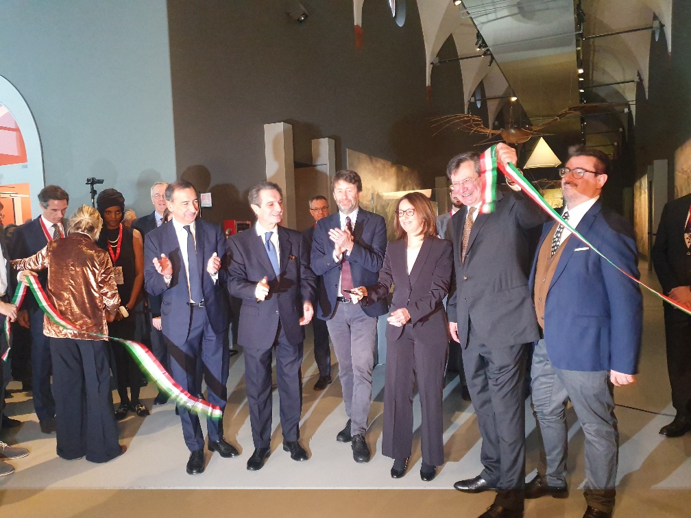 Μια ομάδα ανθρώπων χειροκροτούν με τοκόψιμο μιας κορδέλας εγκαινίων