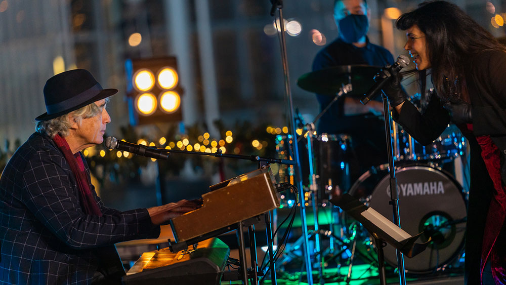 Μια γυναίκα τραγουδά, κοιτόντας τον πιανίστα που τη συνοδεύει, έξω από το Κέντρο Πολιτισμού Ίδρυμα Σταύρος Νιάρχος