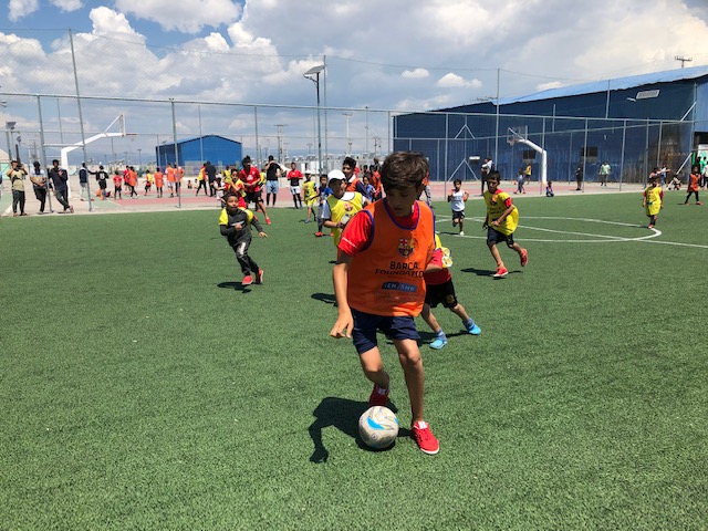 Ένα αγόρι έχει τη μπάλα στα πόδια του κατά τη διάρκεια ενός ποδοσφαιρικού αγώνα