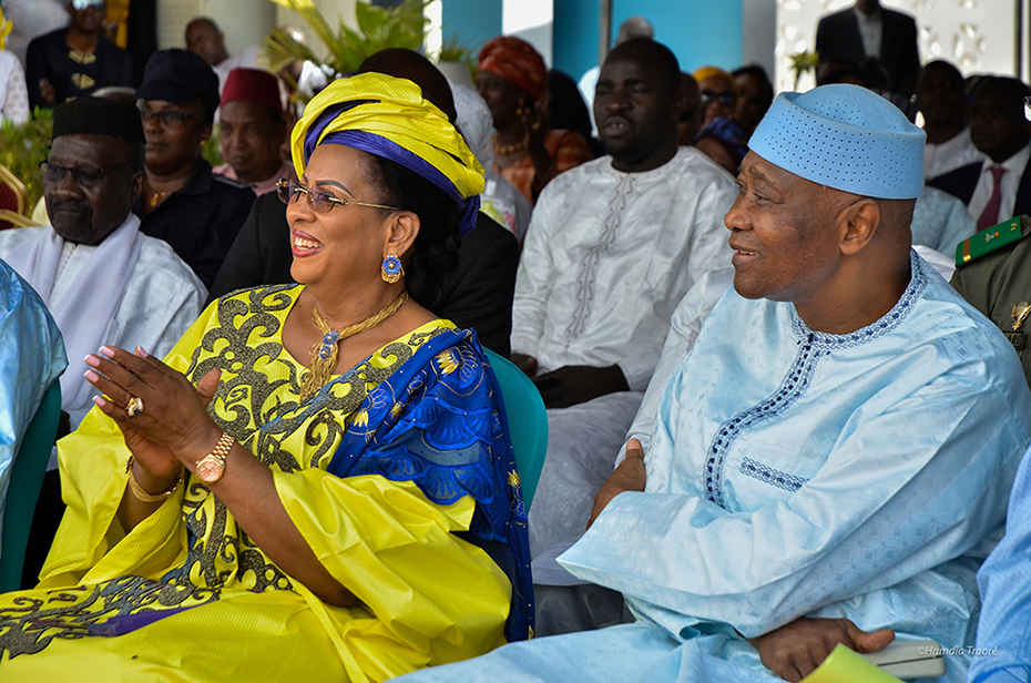 Ένας άντρας και μια γυναίκα κάθονται δίπλα και παρακολουθούν χαμογελώντας 