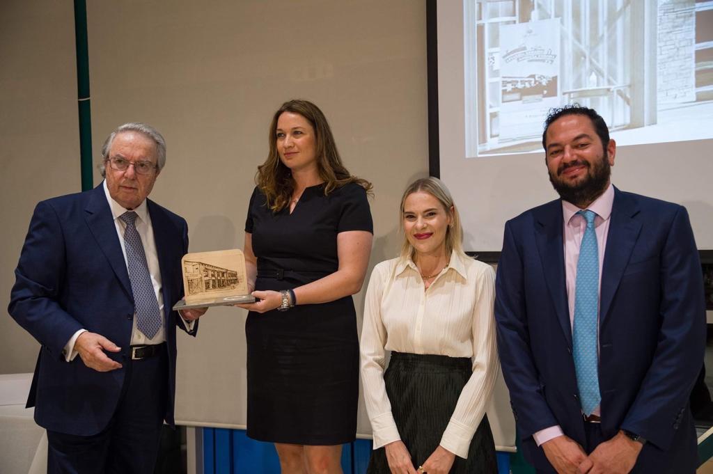 Ο πρόεδρος της φιλεκπαιδευτικής εταιρείας, Γιώργος Μπαμπινιώτης, απονέμει τιμητική πλακέτα στους τρείς εκπροσώπους του Ιδρύματος Σταύρος Νιάρχος (ΙΣΝ).