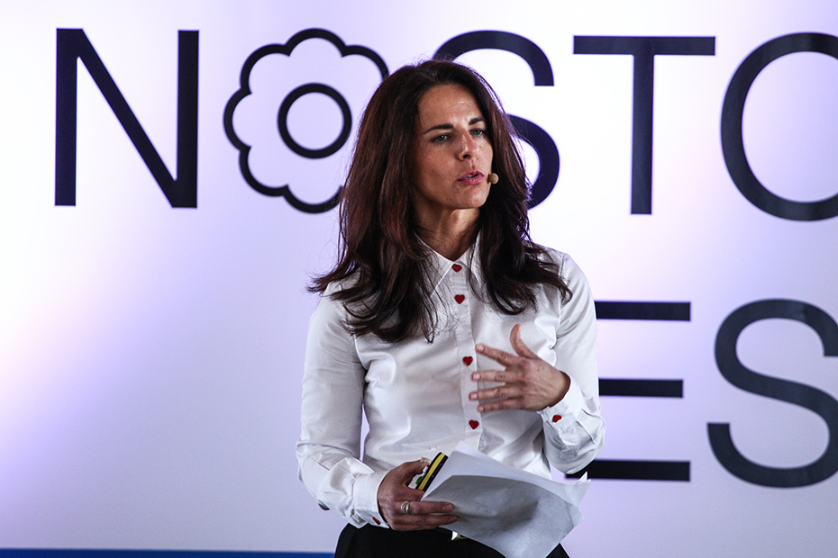 Μια γυναίκα που κρατάει χαρτιά δίνει ομιλία στο Summer Nostos Festival