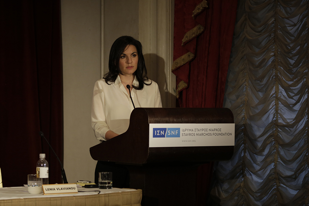 Μια γυναίκα μιλάει στη σκηνή μπροστά σε κοινό