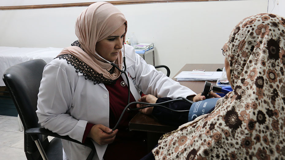 Μια γιατρός παίρνει την πίεση σε μια άλλη γυναίκα 