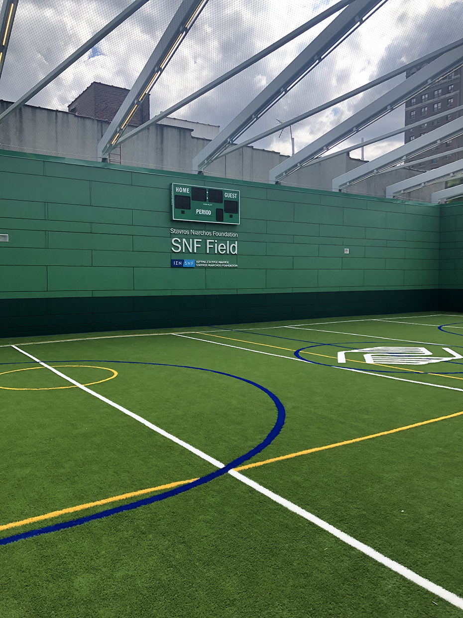 Ένα γήπεδο το οποίο στον τοίχο του γράφει STAVROS NIARCHOS FOUNDATION SNF FIELD 