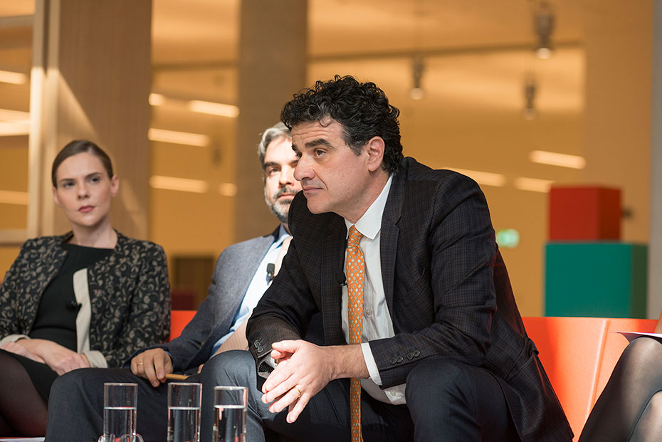 Μια κοντινή φωτογραφία ενός άνδρα που κάθεται σκυμμένος προς τα εμπρός με τους αγκώνες του στα γόνατά του