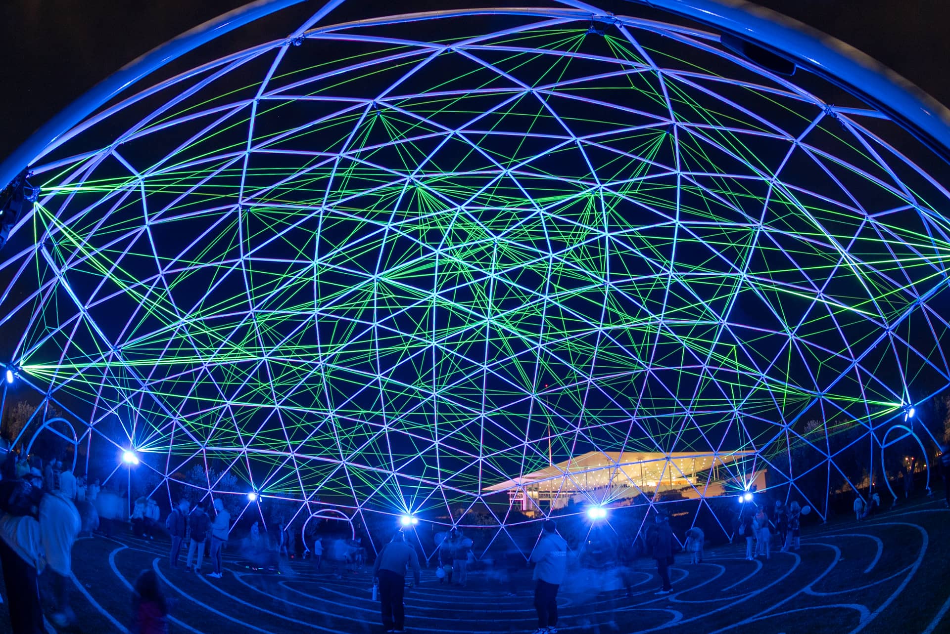 Κόσμος βγάζει φωτογραφίες μέσα σε έναν τεράστιο φωτεινό θόλο. 