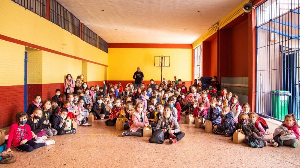 Πολλά παιδάκια κάθονται μαζί στο πάτωμα μιας αίθουσας