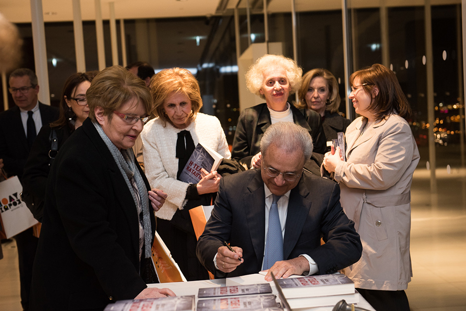 Ο συγγραφέας υπογράφει τα βιβλία των ακροατών στην παρουσίαση του βιβλίου του πρέσβη Βασίλη Κασκαρέλη 