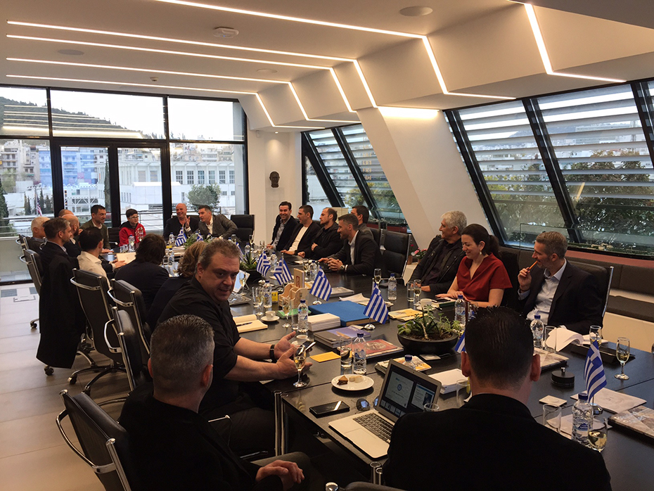 Μέλη της ελληνικής ομάδας των πρωταθλητών του Euro 2004 κάθονται σε αίθουσα συνεδριάσεων και συζητούν με μέλη του Ιδρύματος Σταύρος Νιάρχος