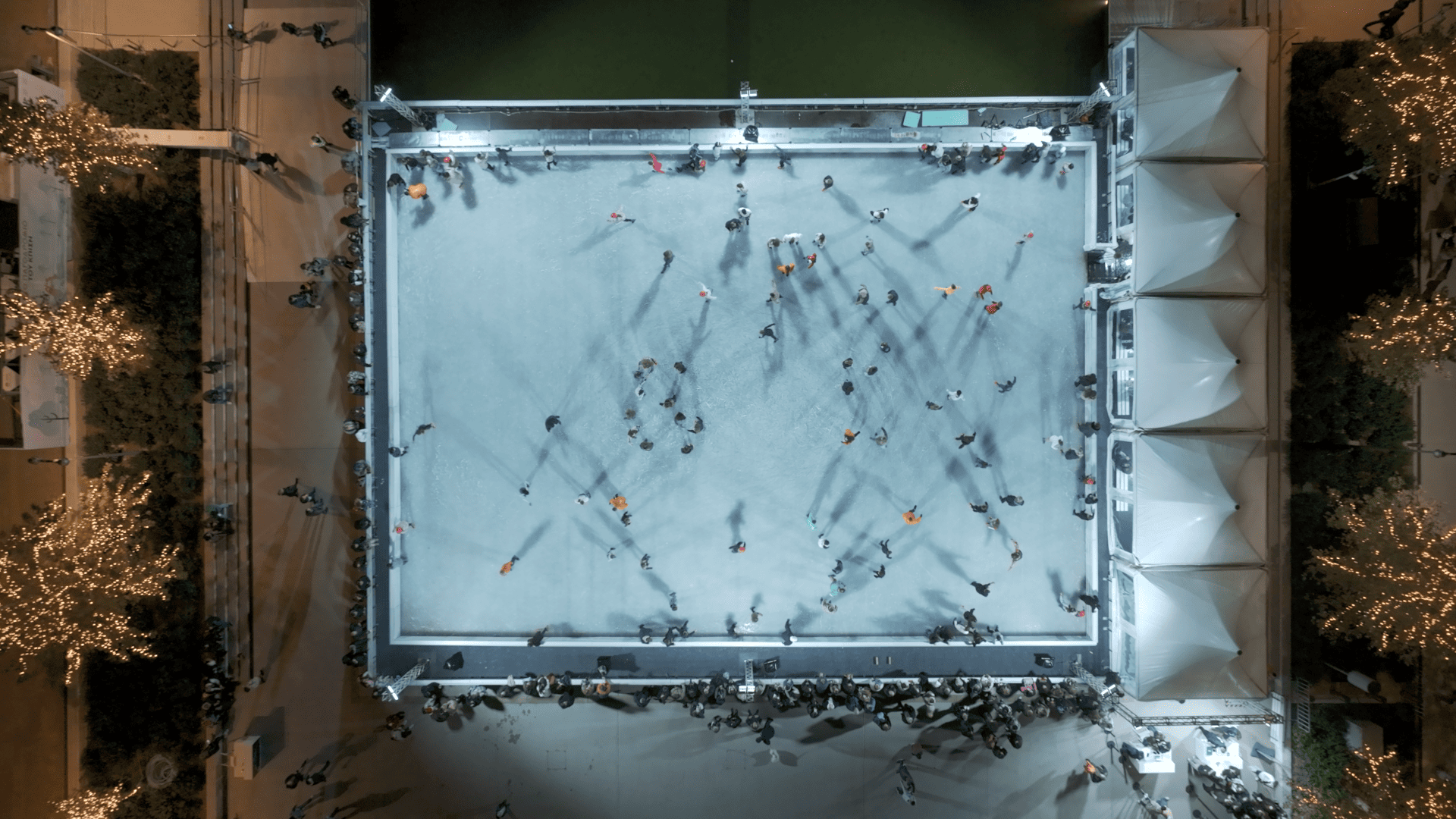 Αεροφωτογραφία ενός μεγάλου παγοδρομίου με ανθρώπους που κάνουν πατινάζ στον πάγο.