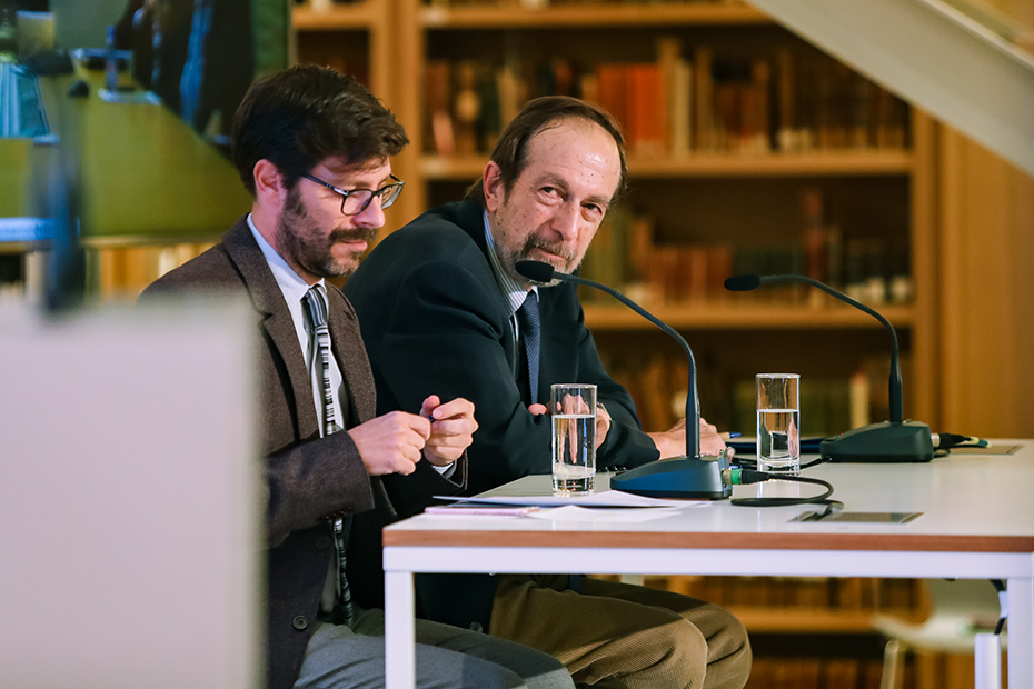 Κοντινή φωτογραφία δύο αντρών οι οποίοι κάθονται στη σκηνή 