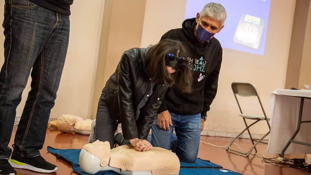 Μια γυναίκα εκτελεί καρδιοαναπνευστική αναζωογόνηση σε μια εκπαιδευτική κούκλα