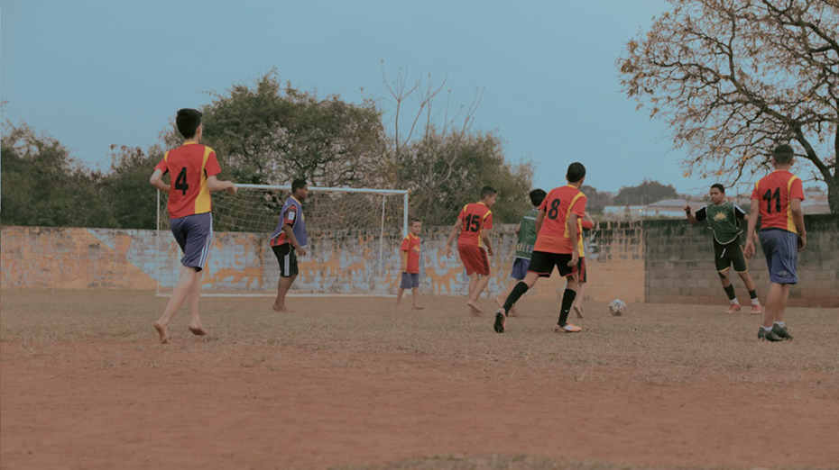 Μια ομάδα παιδιών παίζουν ποδόσφαιρο σε μία αλάνα 