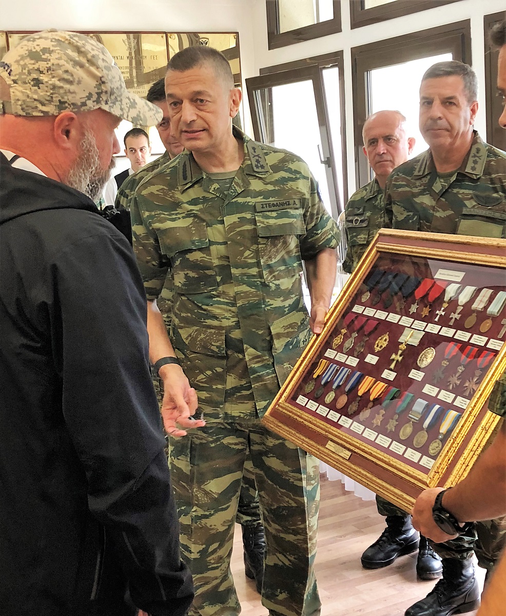 Το μέλος της Ελληνικής Στρατιωτικής Ακαδημίας δείχνει στον Ανδρέα Δρακόπουλο, πρόεδρο του Ιδρύματος Σταύρος Νιάρχος, στρατιωτικά μετάλλια εγκιβωτισμένα σε γυαλί