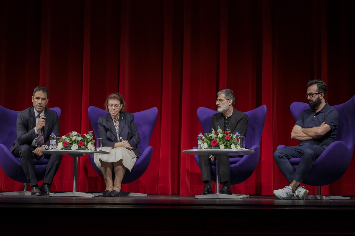 Τρεις άνδρες και μια γυναίκα κάθονται σε πολυθρόνα και μιλούν στην σκηνή της Αίθουσας Σταύρος Νιάρχος του Κέντρου Πολιτισμού Ίδρυμα Σταύρος Νιάρχος