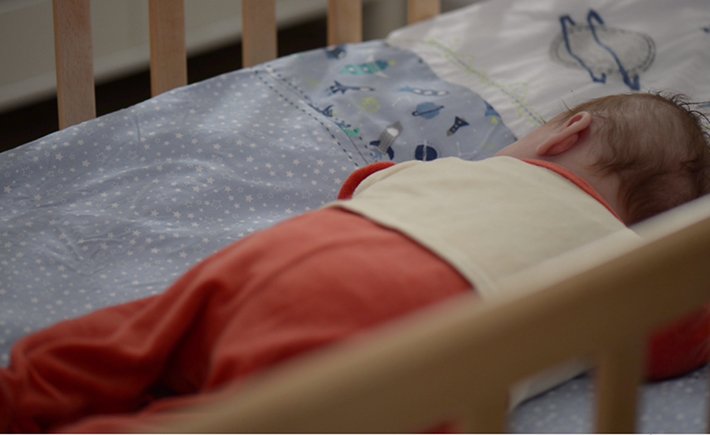 Ένα νεογέννητο μωράκι κοιμάται στην κούνια του 