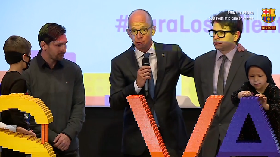 Μέλη του Ιδρύματος Σταύρος Νιάρχος στέκονται δίπλα στον Μέσι και δύο παιδιά