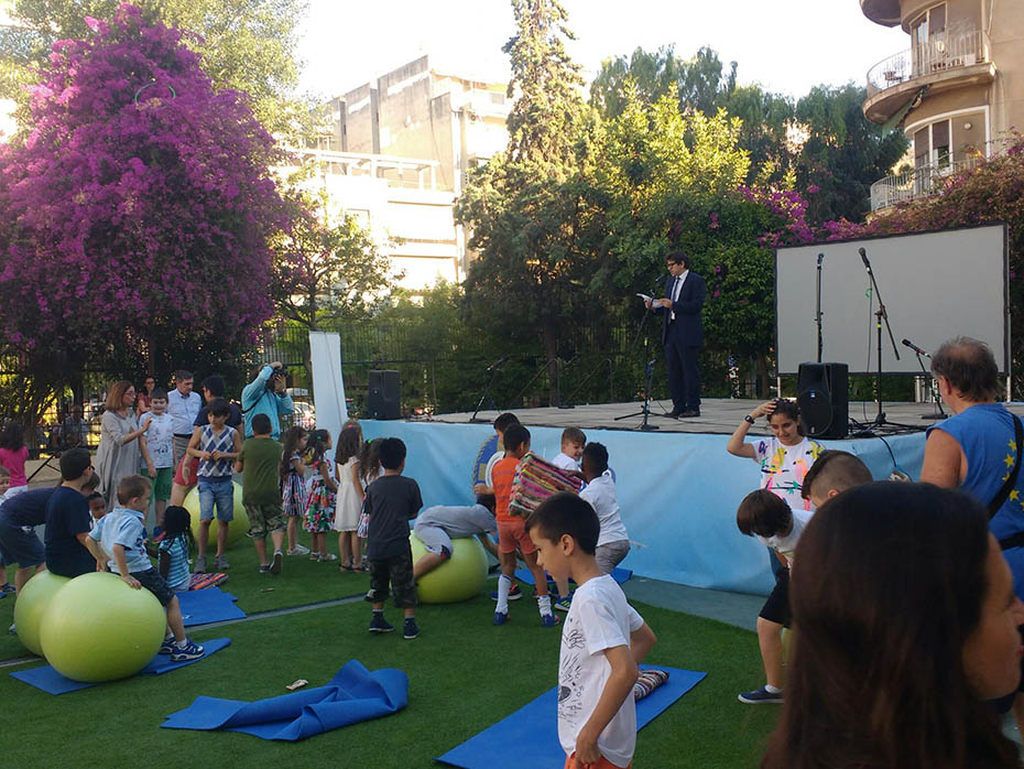 Παιδιά παίζουν στο γρασίδι του προαύλιου χώρου ενός σχολείου 