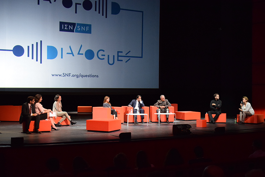 Οκτώ άτομα κάθονται στη σκηνή ως συμμετέχοντες στους Διαλόγους του Ιδρύματος Σταύρος Νιάρχος