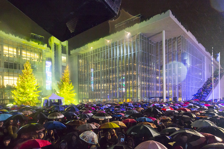Πλήθος ανθρώπων που κρατούν ομπρέλες συγκεντρώνονται την παραμονή της Πρωτοχρονιάς στο Κέντρο Πολιτισμού Ίδρυμα Σταύρος Νιάρχος