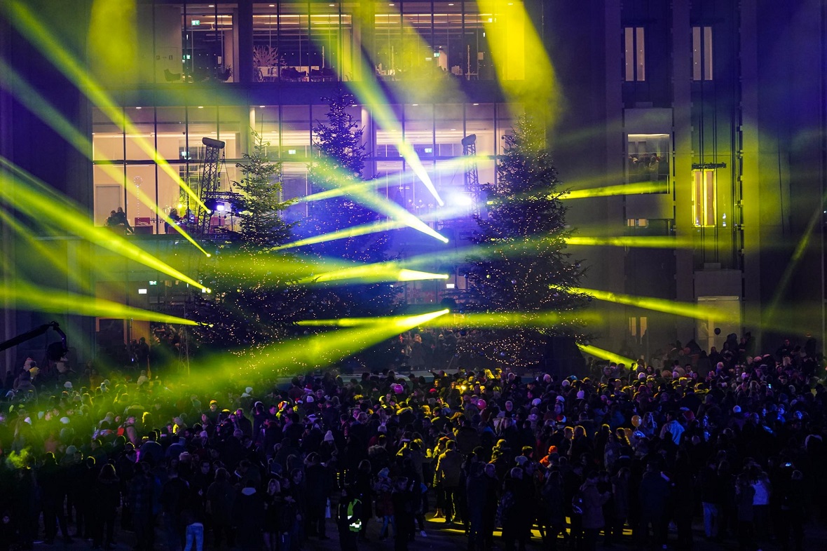 Φωτογραφία που δείχνει πλήθος ανθρώπων να παρακολουθεί τα φωτορυθμικά που ξεπροβάλλουν από τα χριστουγεννιάτικα δέντρα που υπάρχουν στον χώρο