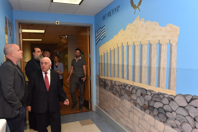 Ο Αντρέας Δρακόπουλος, Πρόεδρος του Ιδρύματος Σταύρος Νιάρχος κοιτάει έναν τοίχο στον οποίο είναι ζωγραφισμένη η ακρόπολη 