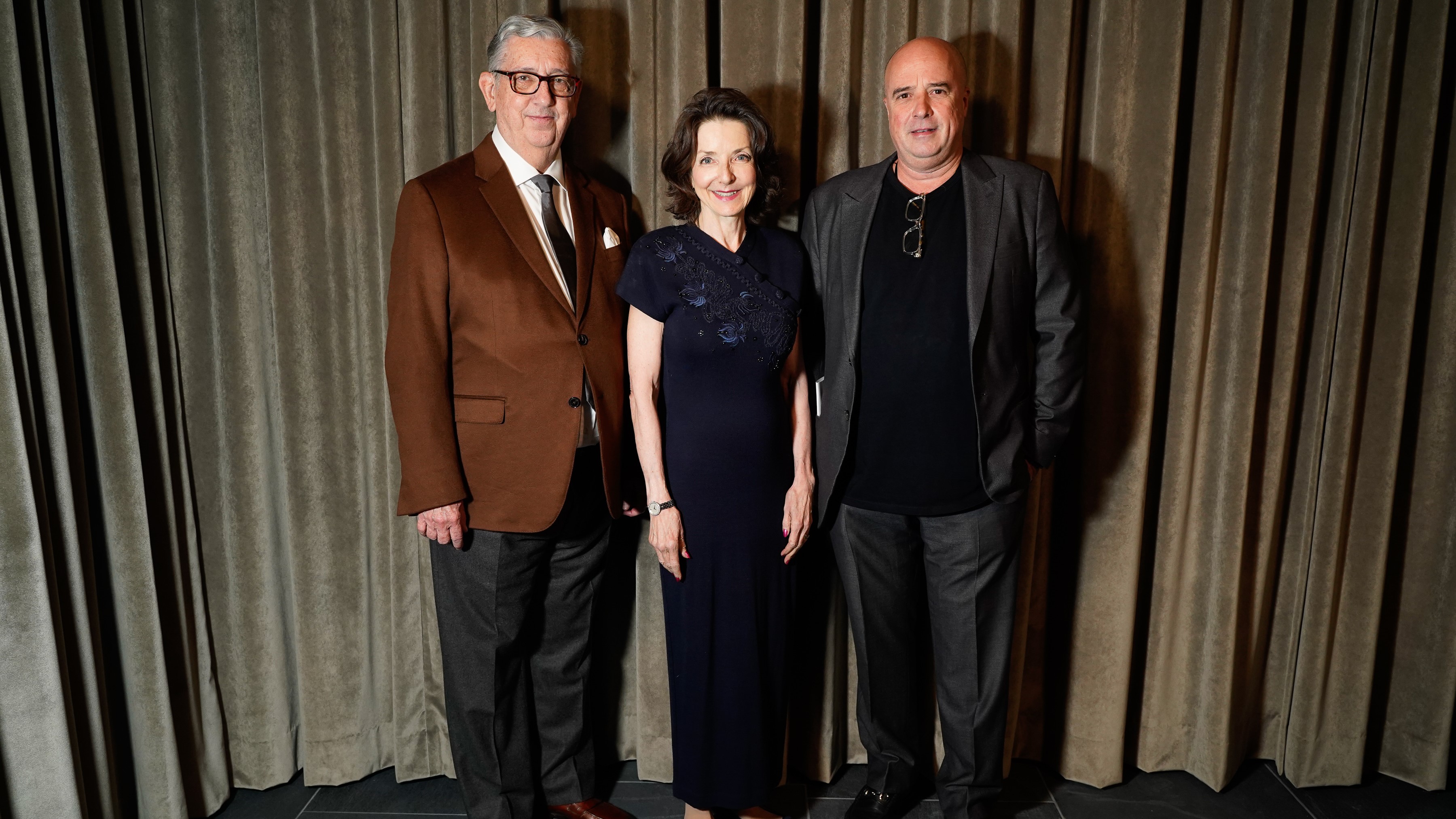 Ο Αντρέας Δρακόπουλος, Πρόεδρος του Ιδρύματος Σταύρος Νιάρχος, σκέκεται με έναν άντρα και μια γύναικα και φωτογραφίζονται  