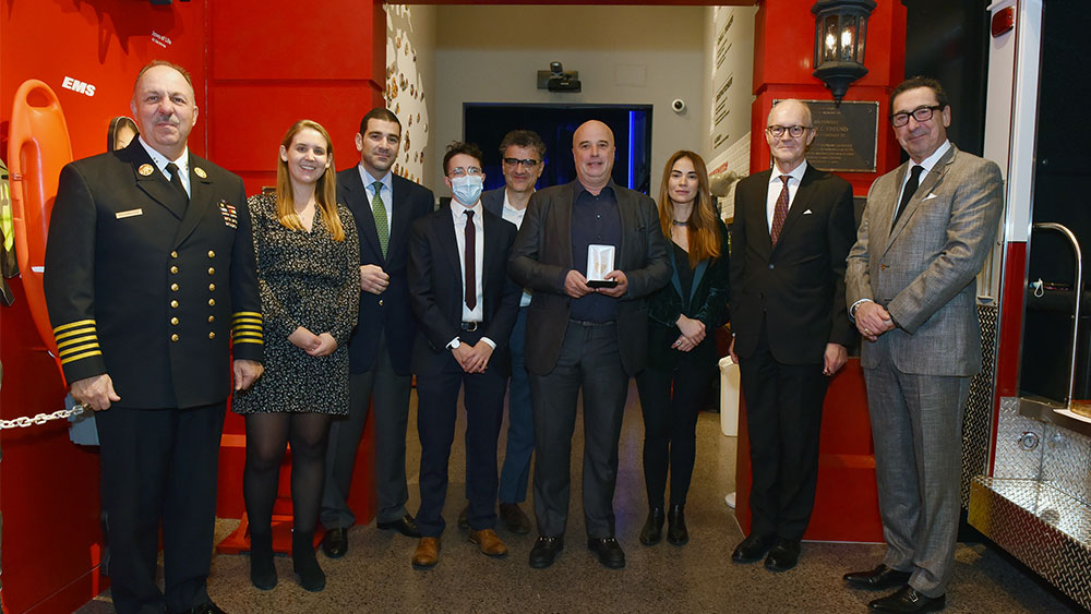 Ο Αντρέας Δρακόπουλος, Πρόεδρος του Ιδρύματος Σταύρος Νιάρχος κρατάει το βραβείο τιμής και στέκεται μαζί με άλλα μέλη του Ιδρύματος Σταύρος Νιάρχος και επίτημα μέλη του Πυροσβεστικού Σώματος της Νέας Υόρκης για μια αναμνηστική φωτογραφία 