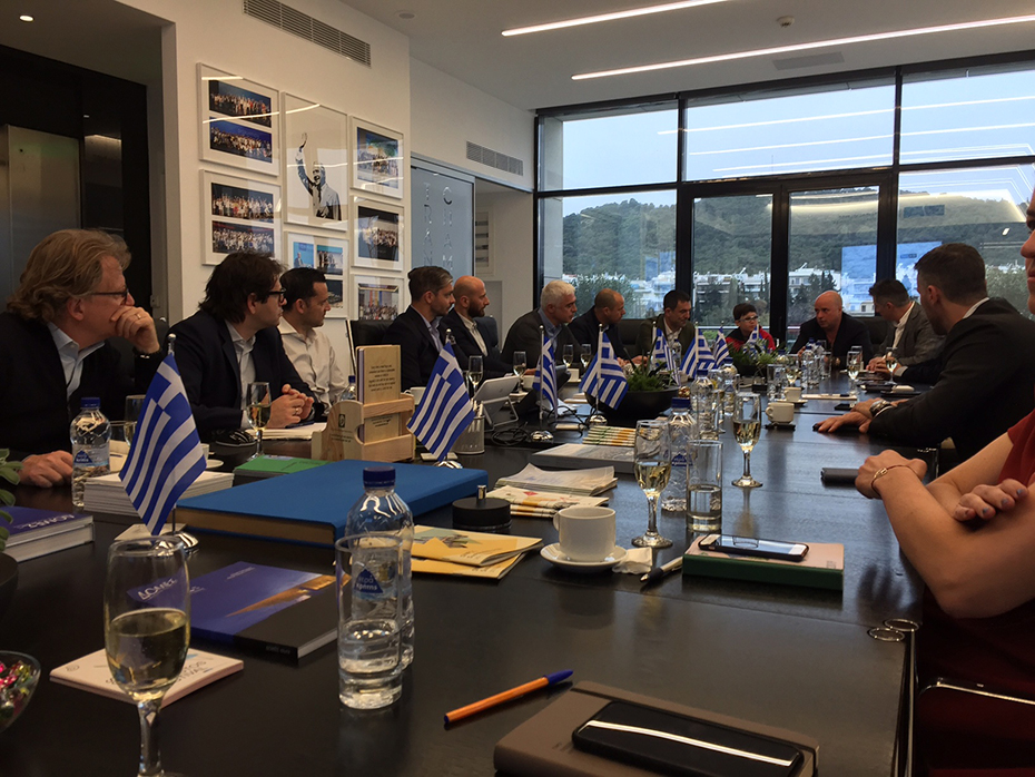 Μέλη της ελληνικής ομάδας των πρωταθλητών του Euro 2004 κάθονται και συνομιλούν με μέλη του Ιδρύματος Σταύρος Νιάρχος, συμπεριλαμβανομένου του προέδρου του Ιδρύματος Σταύρος Νιάρχος Ανδρέα Δρακόπουλου, σε αίθουσα συνεδριάσεων