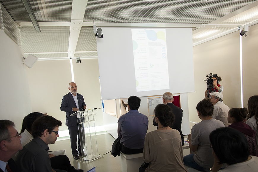 Ένας άντρας που βγάζει λόγο στο βήμα αλληλεπιδρά με το κοινό που τον παρακολουθεί 