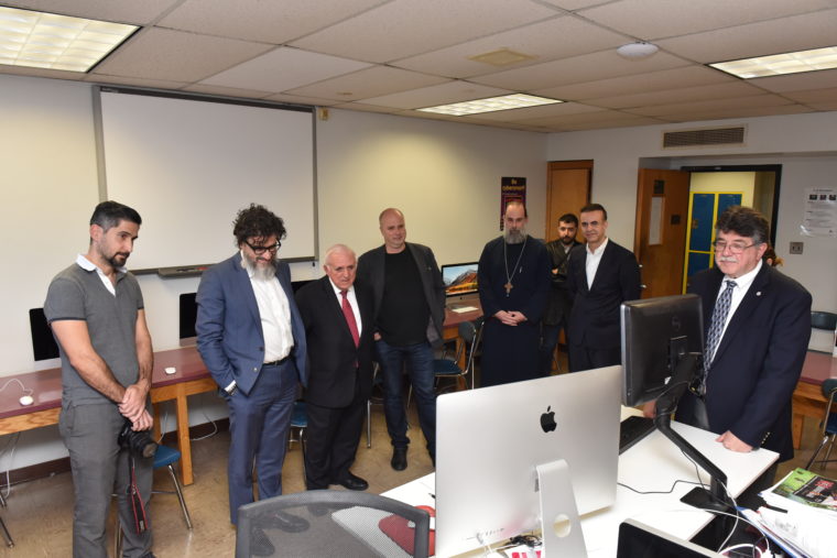 Ο Αντρλεας Δρακόπουλος, Πρόεδρος του Ιδρύματος Σταύρος Νιάρχος, μαζί με άλλους άντρες κοιτάνε στην οθόνη ενός υπολογιστή