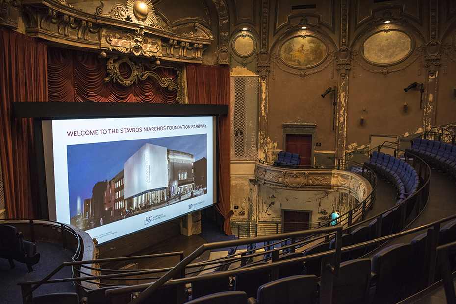 Στην κεντρική σκηνή ενός εμβλυματικού θεάτρου προβάλλεται μια εκόνα η οποία γράφει WELCOME TO THE STAVROS NIARCHOS FOUNDATION PARKWAY και δείχνει ένα μεγάλο μοντέρνο κτήριο 