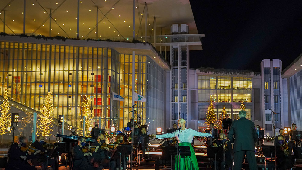 Μια γυναίκα τραγουδά μπροστά από μια ορχήστρα έξω από το Κέντρο Πολιτισμού Ίδρυμα Σταύρος Νιάρχος