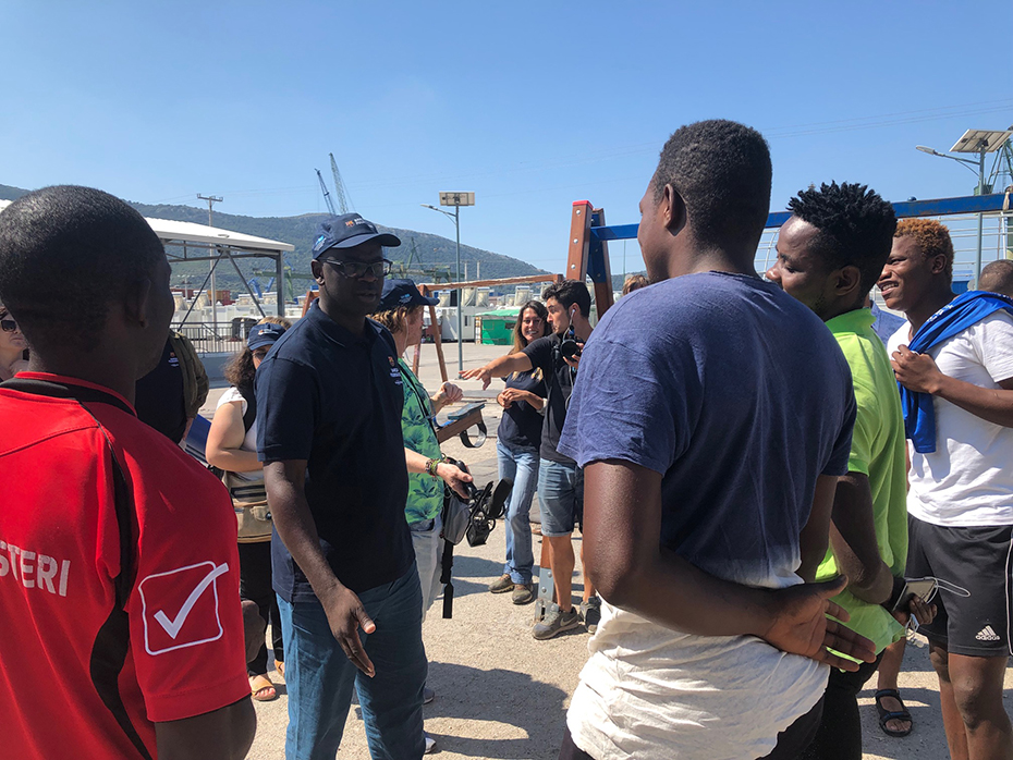 Άντρες συζητούν μεταξύ τους σε μια δημόσια παιδική χαρά ανάμεσα στον κόσμο