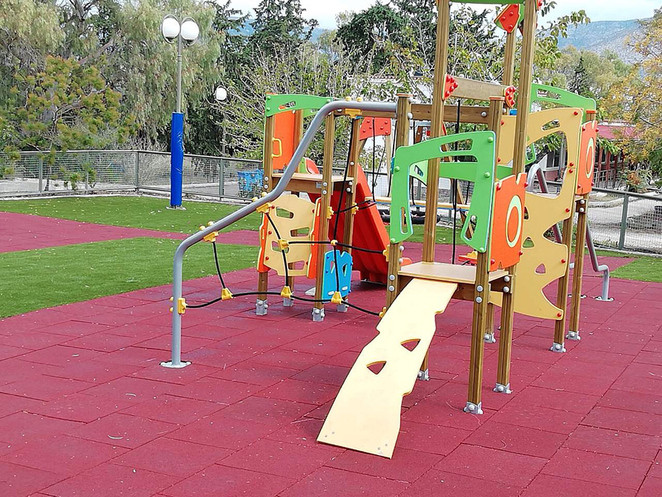 Μια παιδική χαρά πάνω σε μαλακό, προστατευτικό υλικό και γρασίδι