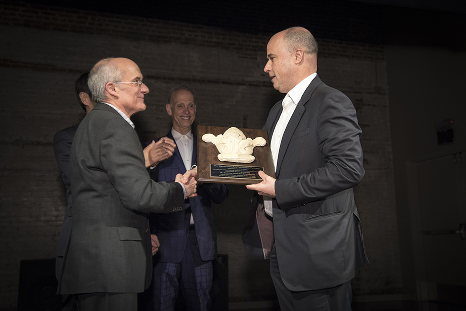 Ένας άντρας παραδίδει στον Αντρέα Δρακόπουλο, Πρόεδρο του Ιδρύματος Σταύρος Νιάρχος ένα βραβείο τιμής