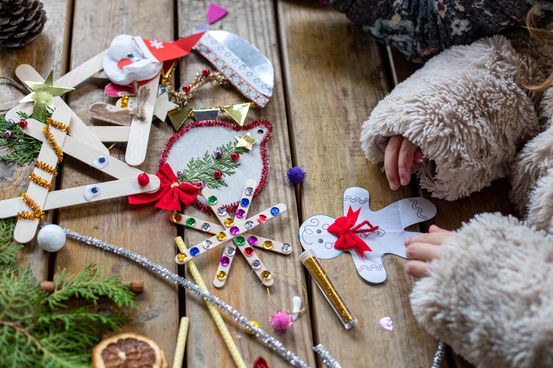 Ένα μικρό κοριτσάκι κάνει χριστουγεννιάτικες χειροτεχνίες και ζωγραφίζει ένα χριστουγεννιάτικο ανθρωπάκι. 