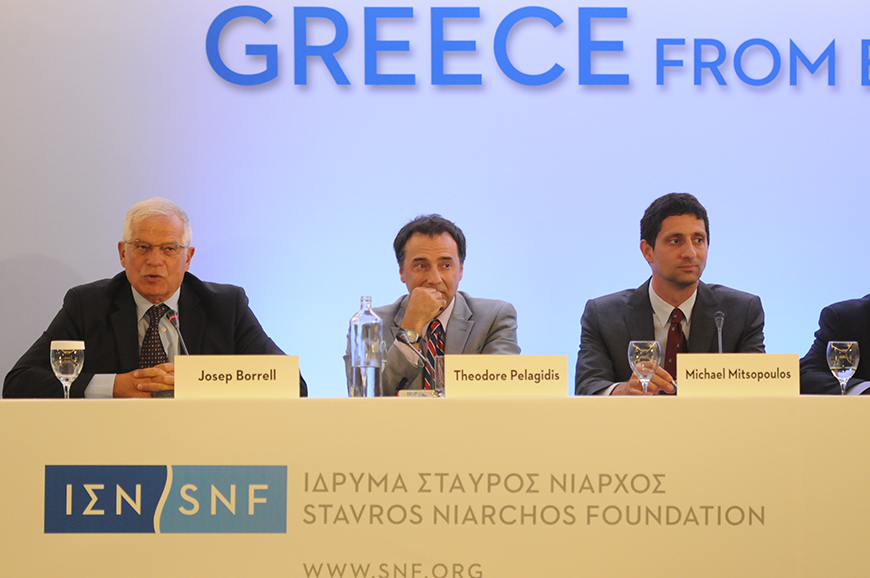 Τρεις άντρες κάθονται δίπλα δίπλα σε ένα τραπέζι το οποίο φέρει το λογότυπο του Ιδρύματος Σταύρος Νιάρχος και ο καθένας έχει μπροστά του ένα μικρόφωνο και καρτελάκι με το όνομά του, Josep Borrell, Theodore Pelagidis, Michael Mitsopoulos